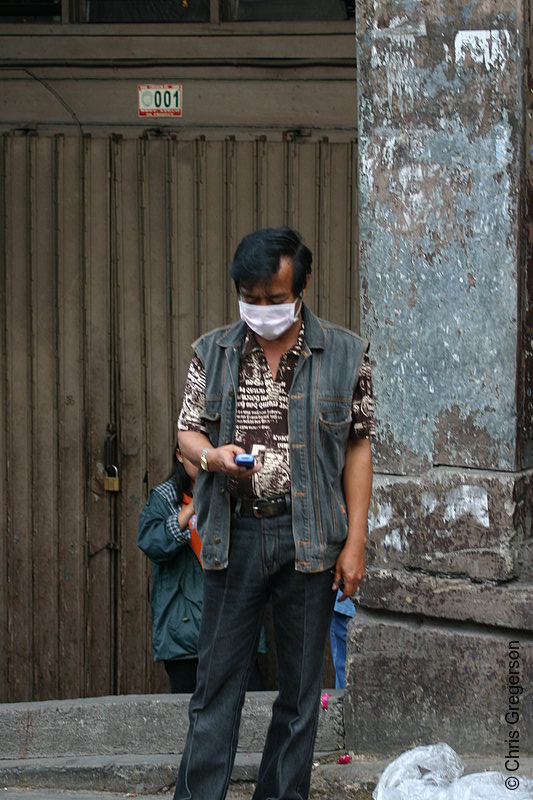 Photo of A Man Texting Wears a Face Mask Due to Meningococcemia Epidemic in Baguio City, Philippines(5737)